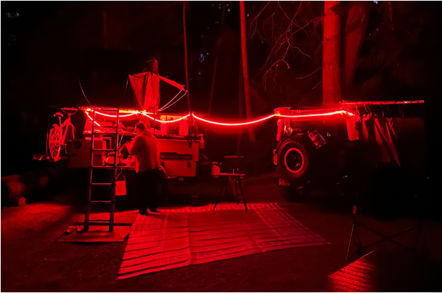 nighttime campsite with red neon lights